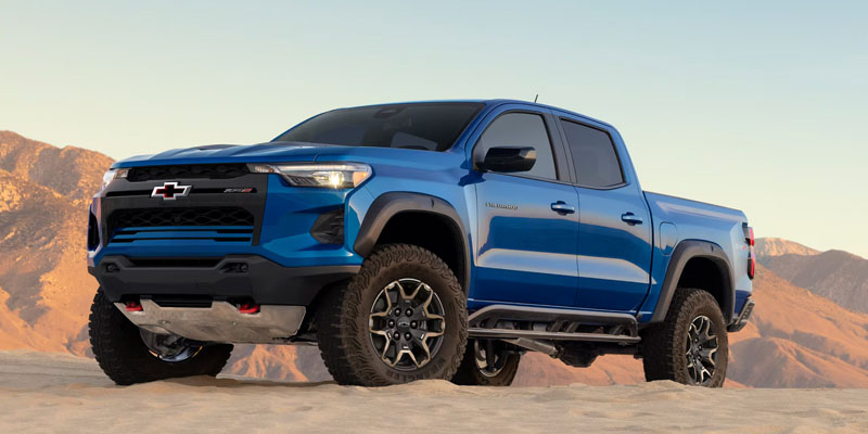 2026 Chevy Colorado parked on sand in between mountains in front side profile